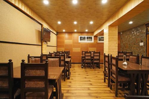 a dining room with wooden tables and chairs at Sher Bengal Darjeeling 100 Mts from Mall Road Couple Friendly in Darjeeling