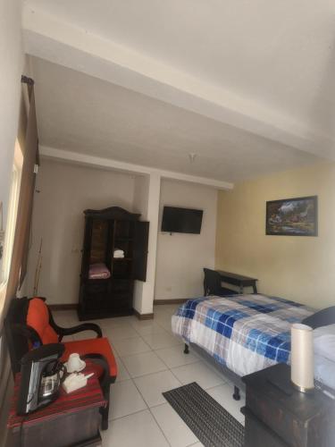 a hotel room with a bed and a tv at Villa Alissa in Quetzaltenango