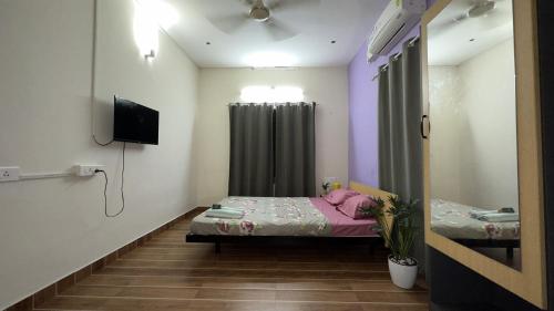 a small room with a bed and a tv at Alchemist Villa-Kazhakootam in Trivandrum