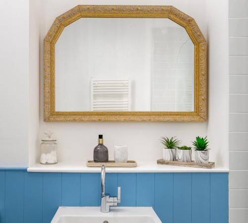 ein Badezimmer mit einem Spiegel über einem Waschbecken in der Unterkunft Westwood Cottage in Dundee