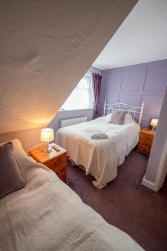 a bedroom with two beds and a window at Marden guest house in Weymouth
