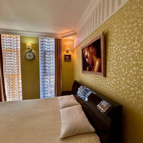a bedroom with a bed and a picture on the wall at Apartment Orbi Sea Tower David in Batumi