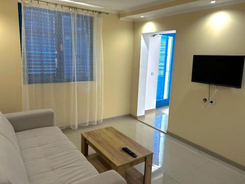 a living room with a white couch and a tv at Stara Vodenica Sokobanja in Soko Banja
