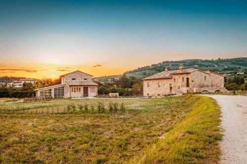 a house on a hill with the sunset in the background at Agriturismo Molinella in Assisi