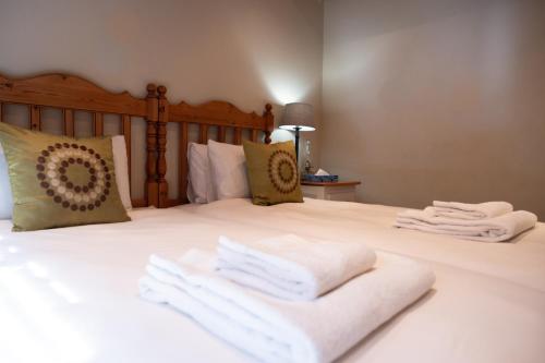 a bedroom with a bed with white towels on it at La La Nathi Country Guesthouse in Harrismith