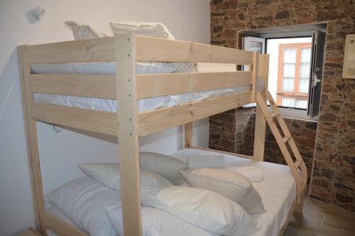 a wooden bunk bed in a room with a window at Tras Do Atrio Casa en el Centro de Betanzos in Betanzos