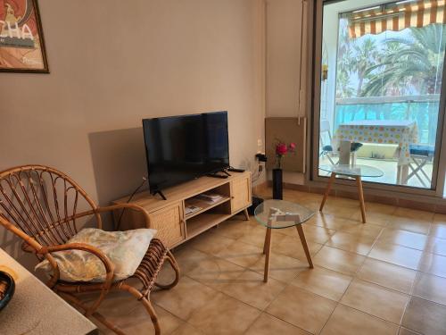 un salon avec une télévision à écran plat sur un centre de divertissement dans l'établissement CCI - Cannes Midi Front de Mer - LEC -, à Cannes