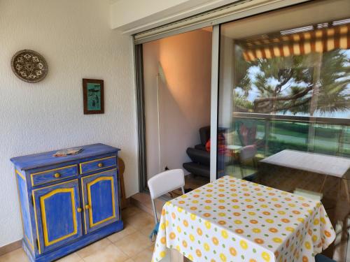 une pièce avec une table, une armoire bleue et une fenêtre dans l'établissement CCI - Cannes Midi Front de Mer - LEC -, à Cannes