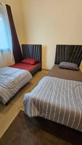 two beds sitting next to each other in a room at Hostel Faye in Abu Dhabi