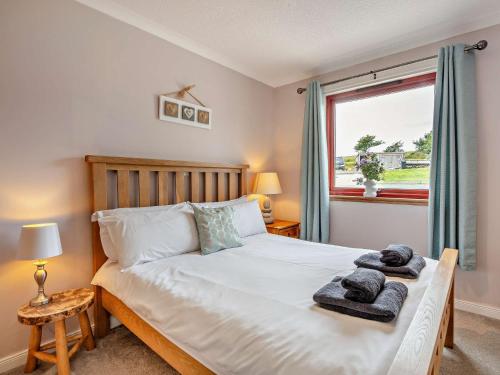 a bedroom with a bed with towels on it at 4 Bed in Blackwaterfoot 95184 in Blackwaterfoot