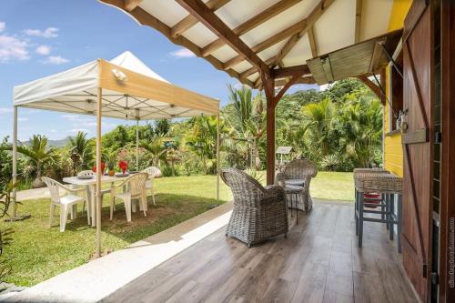 a patio with a table and chairs and an umbrella at Bungalow Cactus in Le François