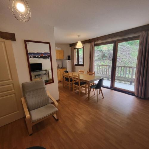 un salon avec une table et des chaises de salle à manger dans l'établissement Appartements 3 vallées, piscine et sauna, à Orelle