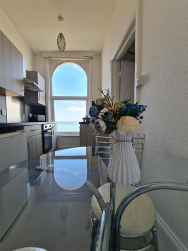 a kitchen with a glass table with a vase of flowers at Farina Holiday apartments in Bridlington