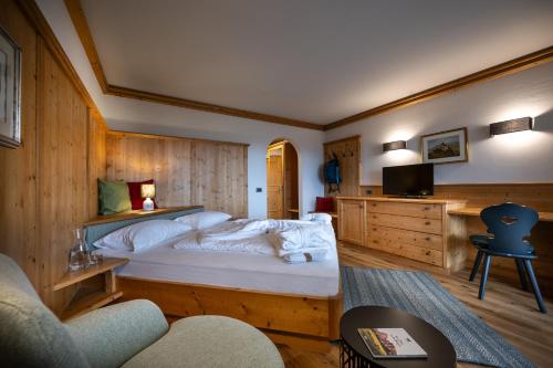 a bedroom with a large white bed in a room at Activehotel Diana in Siusi