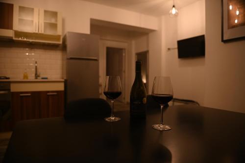 two glasses of wine sitting on a table in a kitchen at Arin l Aparthotel #1 in Craiova