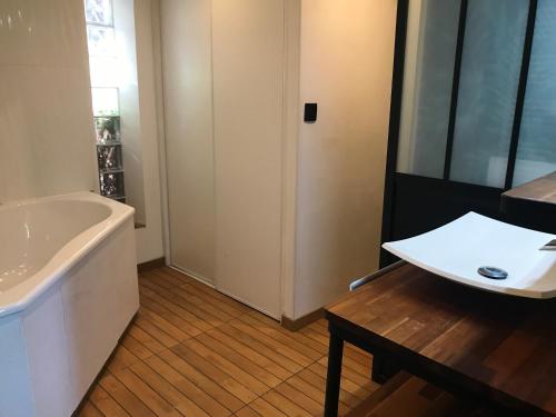 a bathroom with a sink and a tub and a table at HAVRE DE PAIX si près de PARIS et JO 2024 in Férolles-Attilly