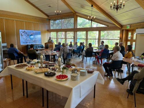 a group of people sitting at tables in a room at Alværa Misionssenter Sommerhotel in Lavik