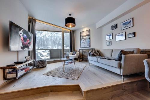 a living room with a couch and a tv at Portillo 823 in Val dʼIsère