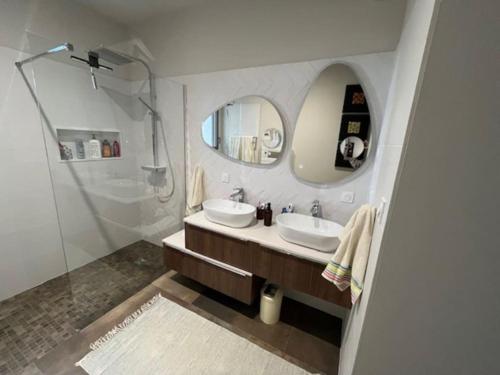 La salle de bains est pourvue de 2 lavabos, d'une douche et d'un miroir. dans l'établissement Belle contemporaine avec piscine proche d'Aix en Provence, à Rognes