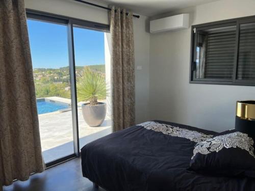 - une chambre avec un lit et une grande fenêtre avec une terrasse dans l'établissement Belle contemporaine avec piscine proche d'Aix en Provence, à Rognes