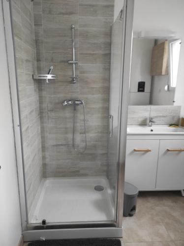 a shower with a glass door in a bathroom at Chez CHARLETTE in Les Malots