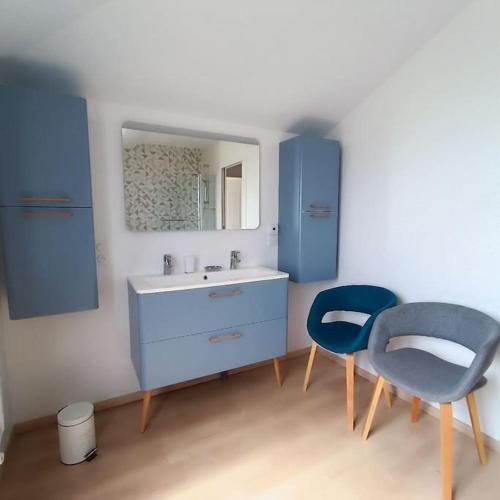 La salle de bains est pourvue d'un lavabo et de 2 chaises bleues. dans l'établissement Maison avec jardin Disneyland, à Favières