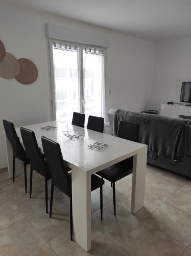 a white table and chairs in a living room at Chez CHARLETTE in Les Malots