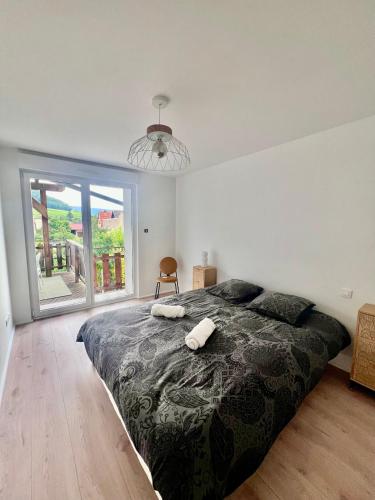 une chambre avec un grand lit et une grande fenêtre dans l'établissement gites du bel Alsace cote vignoble, à Westhalten