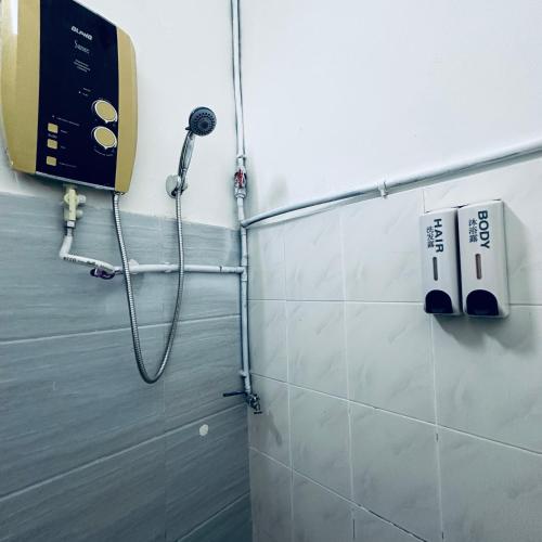 a shower in a bathroom with a phone on the wall at MayiiVip Homestay - Menglembu in Ipoh
