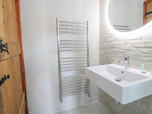 a white bathroom with a sink and a mirror at The Onibury in Craven Arms