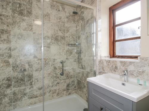 a bathroom with a tub and a sink and a shower at The Onibury in Craven Arms