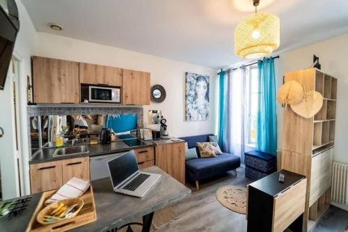 - une cuisine avec une table et un ordinateur portable dans l'établissement Double Appart Hypercentre Blois à 5 min Château, à Blois