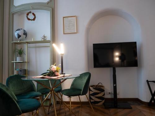 a living room with a table and chairs and a television at Mercanti e Viaggiatori in Turin