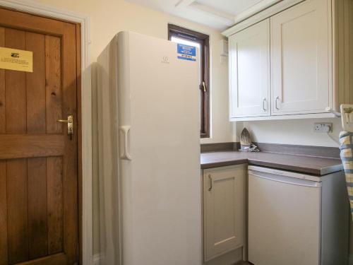 a white refrigerator in a kitchen with white cabinets at The Park in Craven Arms