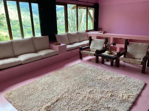 ein Wohnzimmer mit einer Couch und einem Teppich in der Unterkunft Varanda Itaipava! in Petrópolis