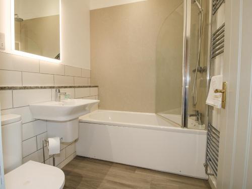 a bathroom with a sink and a tub and a toilet at The Park in Craven Arms