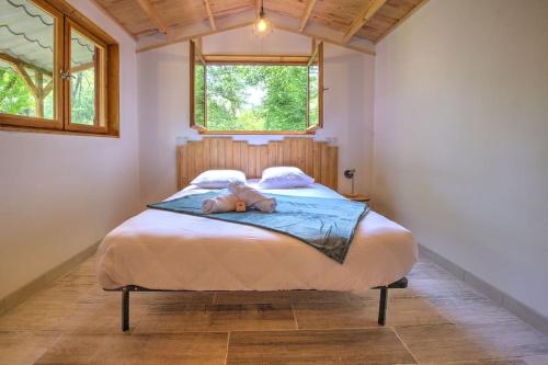 a teddy bear laying on a bed in a bedroom at Le Chalet du Manoire in Saint-Laurent-sur-Manoire