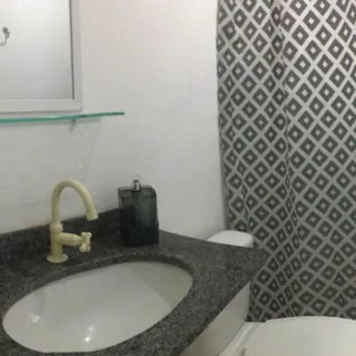 a bathroom with a sink and a toilet at Apartamento Confortável in Natal