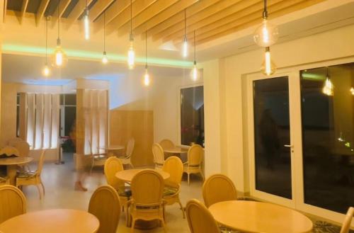 a dining room with tables and chairs and lights at Hospedaria Frangaria in Faro