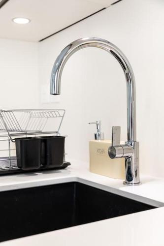 - un évier dans une cuisine avec un robinet et un évier dans l'établissement ZenBNB - Rova - 4 pers - Centre Ville- Wifi, à Annemasse