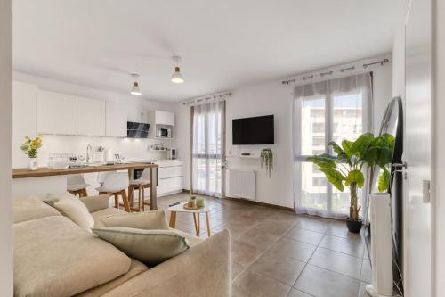 un salon avec un canapé et une cuisine dans l'établissement ZenBNB - Rova - 4 pers - Centre Ville- Wifi, à Annemasse