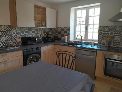 a kitchen with a sink and a dishwasher at Gite Chez Laurette 12 in Sainte-Eulalie-dʼOlt