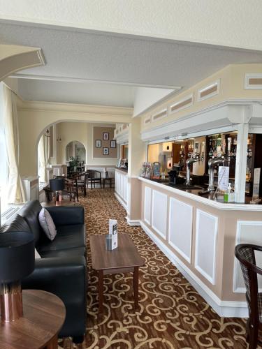 a living room with a couch and a bar at Clifton Hotel in Scarborough