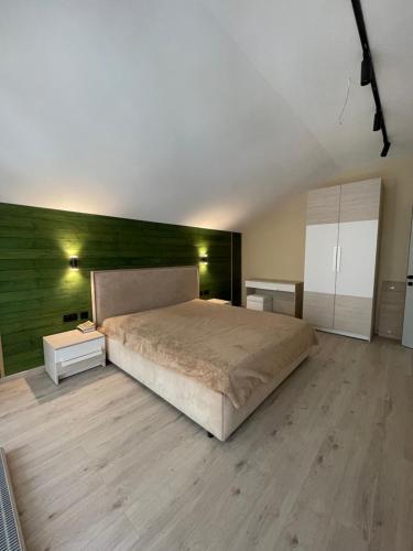 a bedroom with a bed and a green wall at Ormanhouse in Shchūchīnsk
