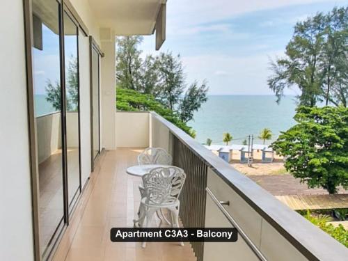 a balcony with a table and chairs and the ocean at By the Sea- Pool and Sea View in Batu Ferringhi