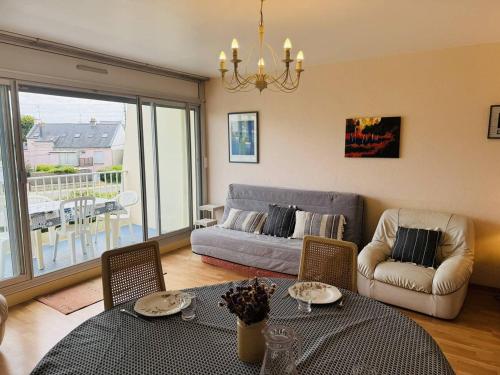 un salon avec un canapé, une table et des chaises dans l'établissement 3 pièces centre ville, 4 min à pied plage, parking, wifi, à Quiberon