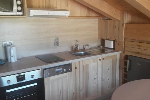 une cuisine avec un évier et une cuisinière dans l'établissement Appartement sur les pistes de Megève, à Megève