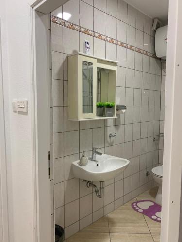 a bathroom with a sink and a mirror and a toilet at LUXURY ROOMS BURE in Murter