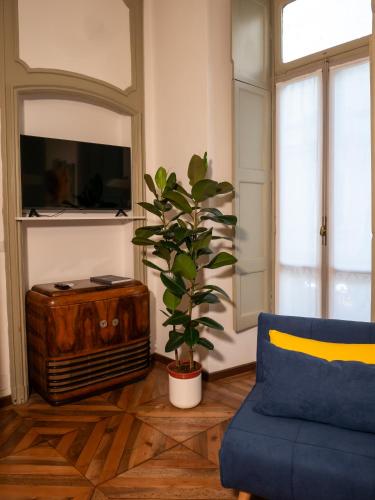 a living room with a blue couch and a plant at Mercanti e Viaggiatori in Turin