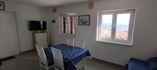 ein Esszimmer mit einem Tisch und einem Fenster in der Unterkunft Apartman Maestral in Drašnice